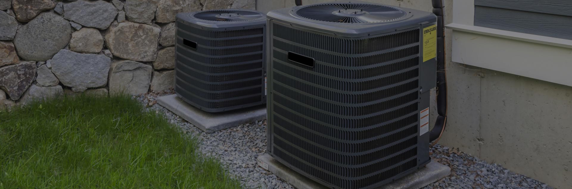 Outdoor AC condensers installed beside a home — photo from Northwest Heating site